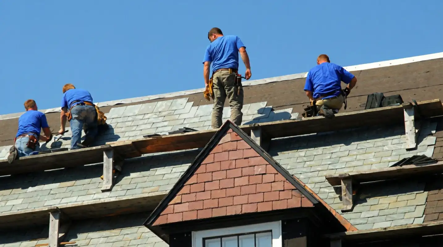 Roof replacement in progress with a team of professional contractors installing new shingles on a residential home in Worcester, MA